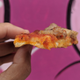 hand holding pizza